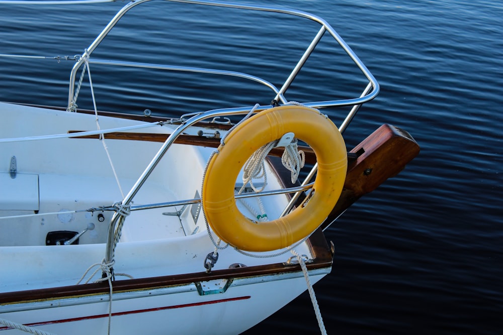 ein weißes Boot, an dem ein gelber Rettungsring befestigt ist