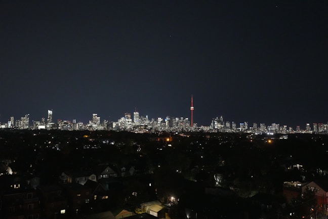 Nighttime skyline of Karachi illuminated with city lights and a red news ticker overlay.