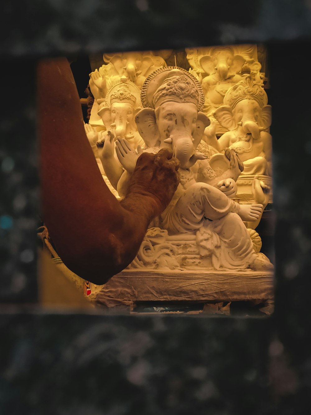 a hand touching a statue of a buddha