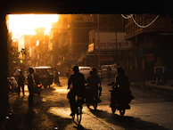 A group of riders cruising through Mumbai’s bustling streets at dusk, their bikes reflecting city lights.