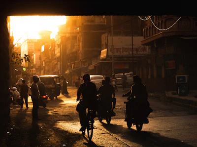 An urban street scene at dusk with neon-lit bikes lined up, capturing the energy of India's young riders.