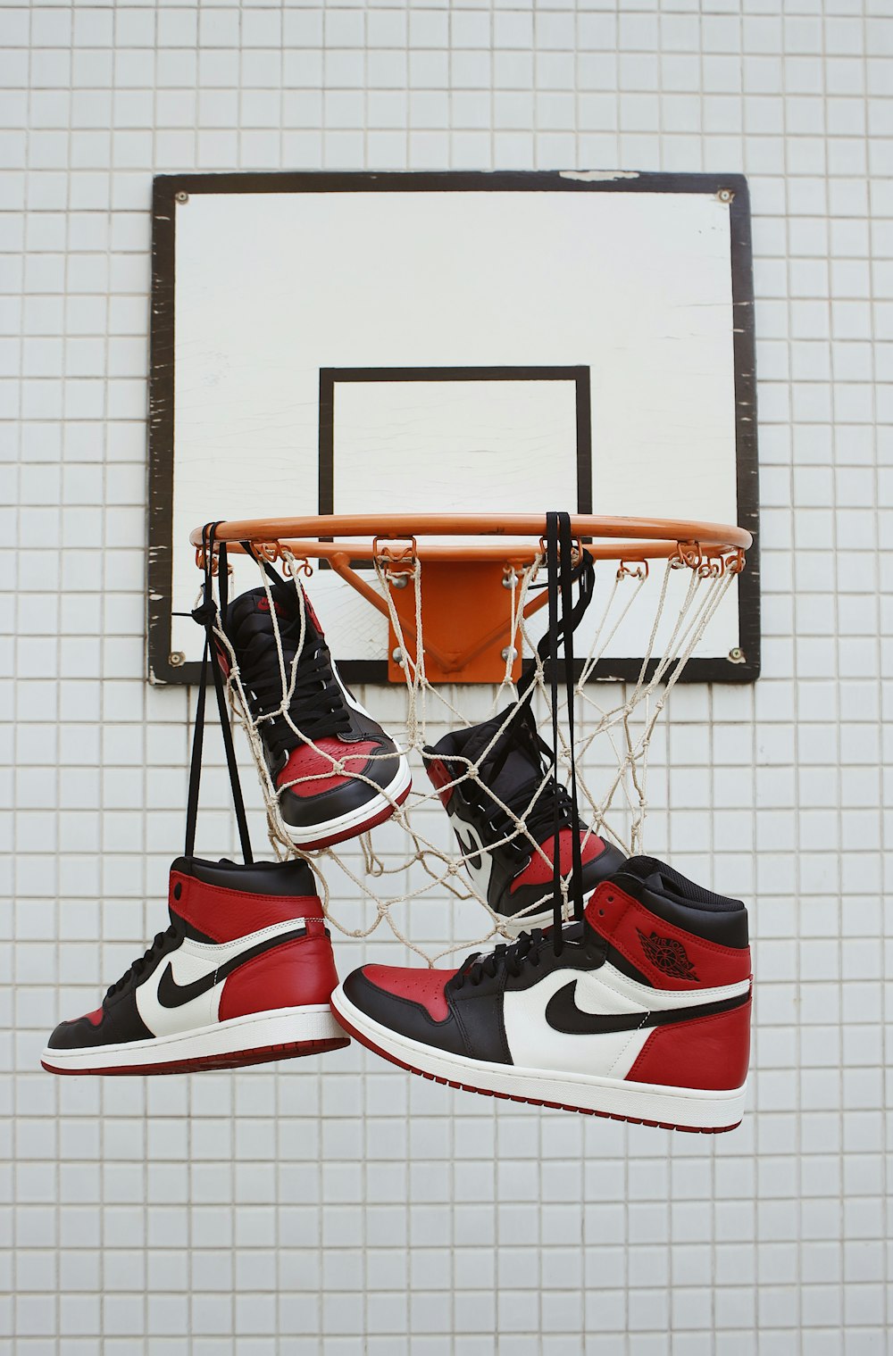 a pair of shoes hanging from a basketball hoop