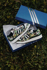 Close-up of a pair of olive green army jungle shoes with a return box in the background.