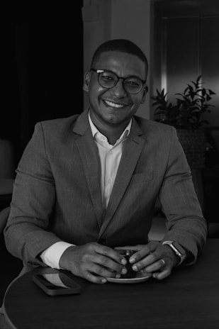 A smiling recruiter reviewing resumes with a cup of tea nearby, reflecting local work culture.