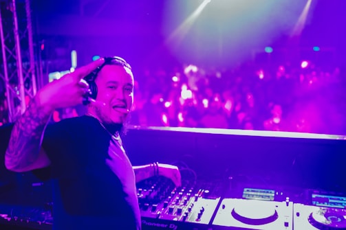 Close-up of DJ mixing tracks with enthusiastic crowd in background.