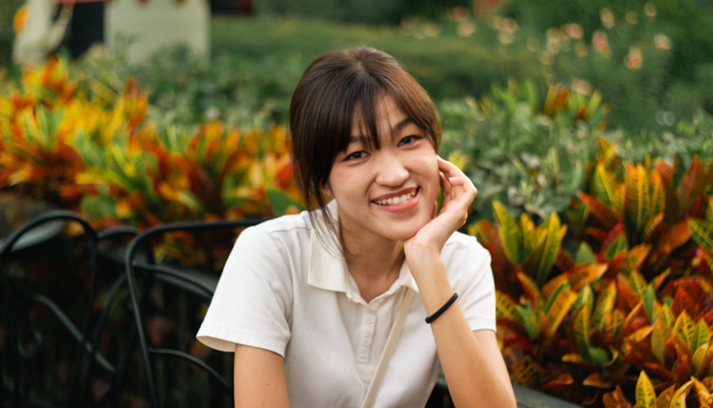 a woman sitting on a bench smiling at the camera