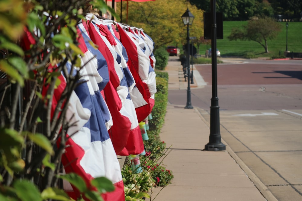 a row of red, white and blue flags on a sidewalk
