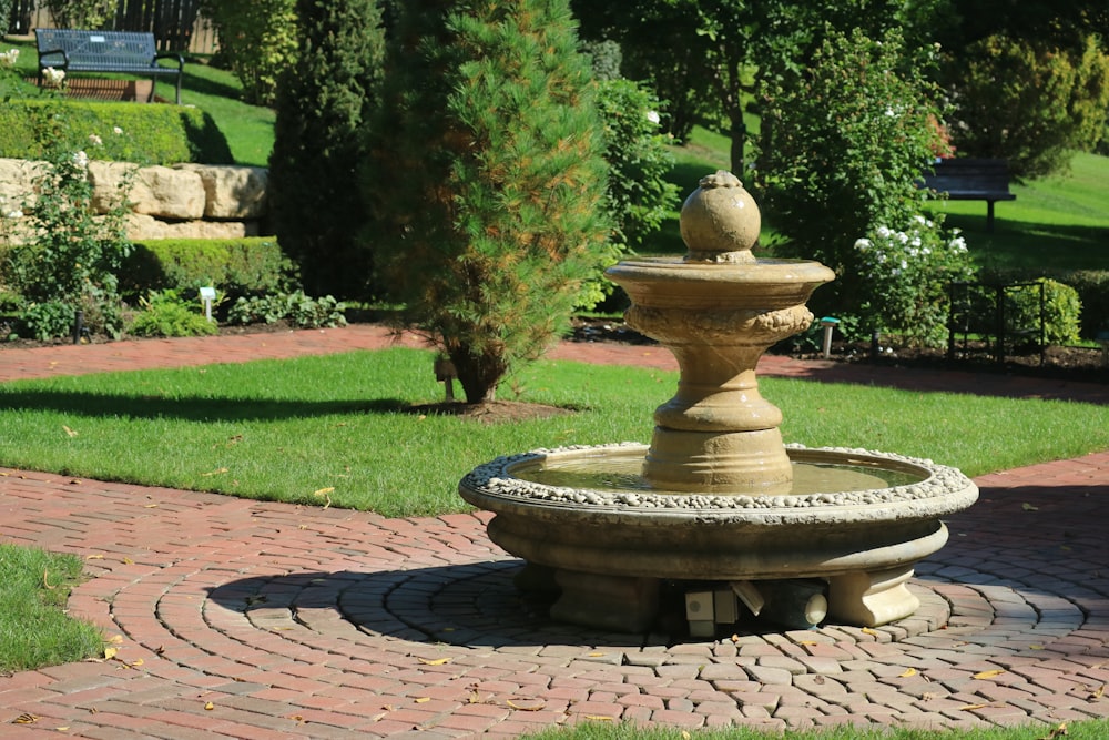 a stone fountain in the middle of a brick walkway