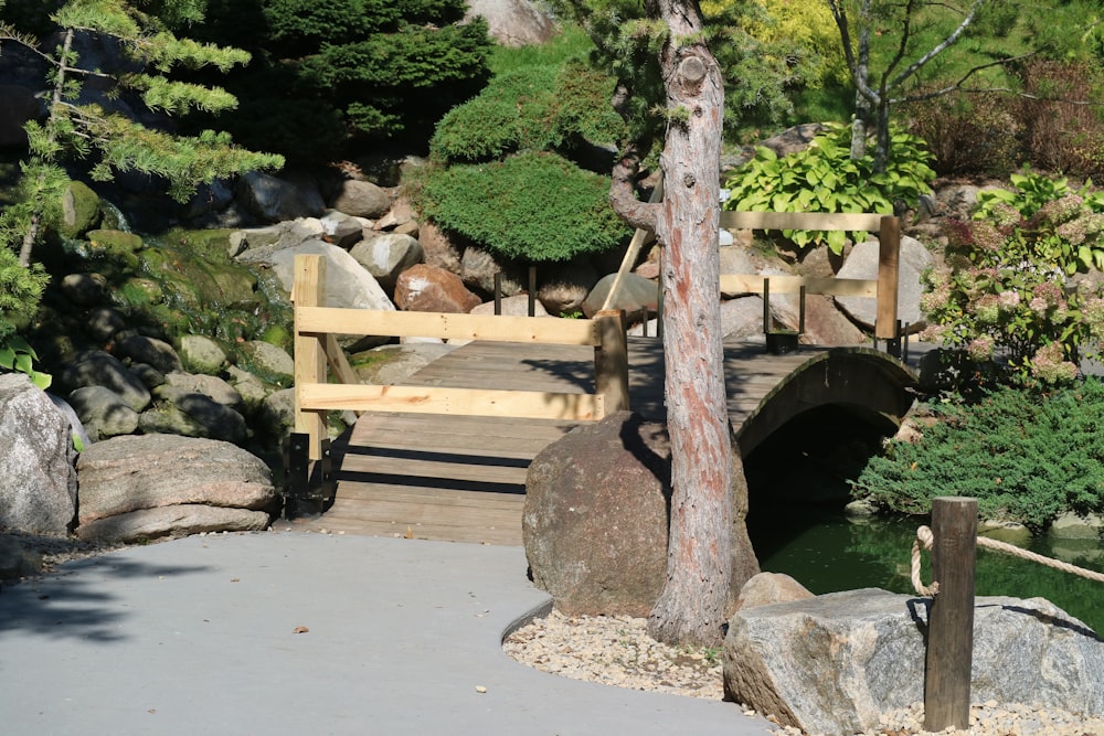 a wooden bridge over a small stream in a park