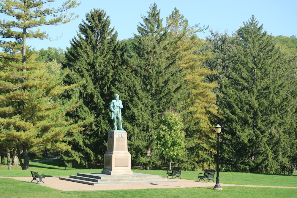 a statue in a park surrounded by trees