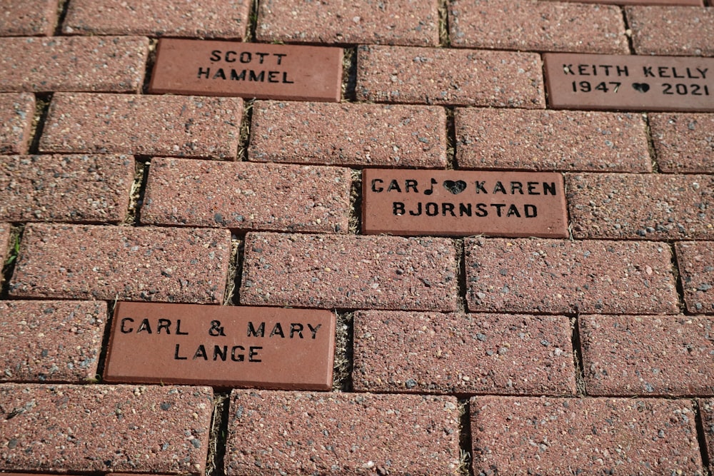 a brick walkway with names and hearts on it
