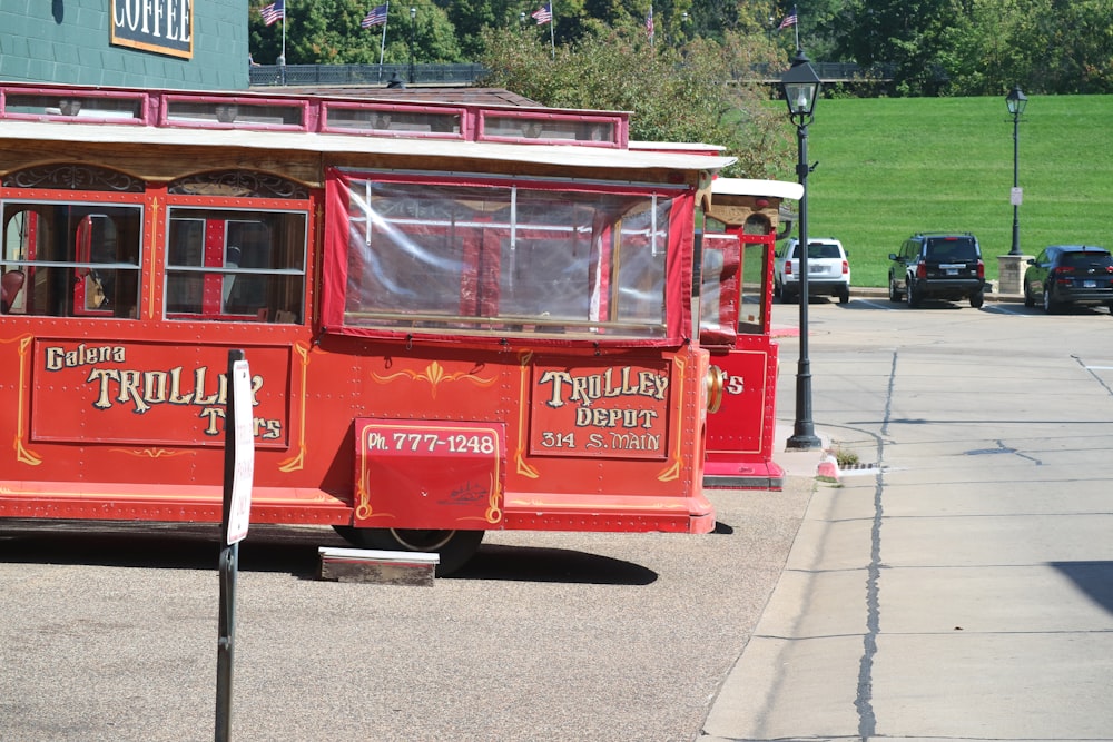 a red trolley car parked on the side of the road