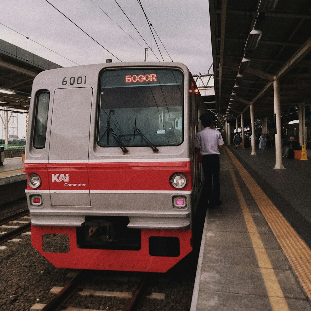 a red and white train pulling into a train station