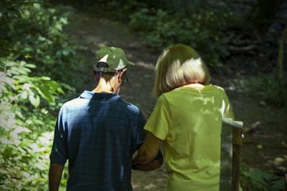 a man and a woman are walking in the woods