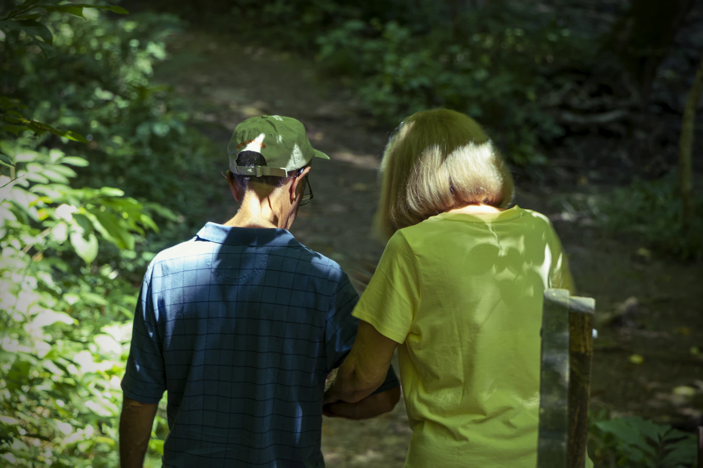 An older couple walking together on a wooded path