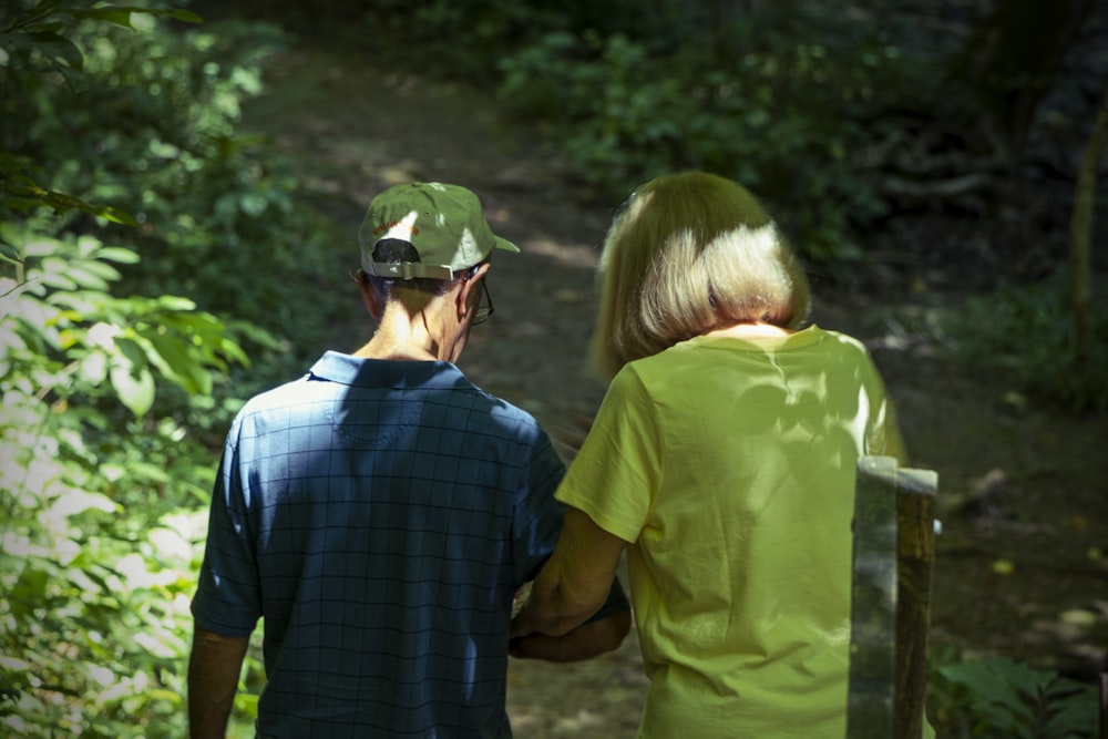a man and a woman are walking in the woods