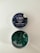 A tin of CBD gummies labeled 'Blueberry Dream' with an open lid revealing square-shaped green gummies inside. The label indicates it contains 25mg of CBD and is THC free. The tin has a dark blue label with images of blueberries and leaves.