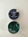 A tin of CBD gummies labeled 'Blueberry Dream' with an open lid revealing square-shaped green gummies inside. The label indicates it contains 25mg of CBD and is THC free. The tin has a dark blue label with images of blueberries and leaves.