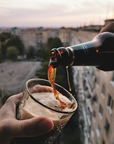 a person pouring a beverage into a glass