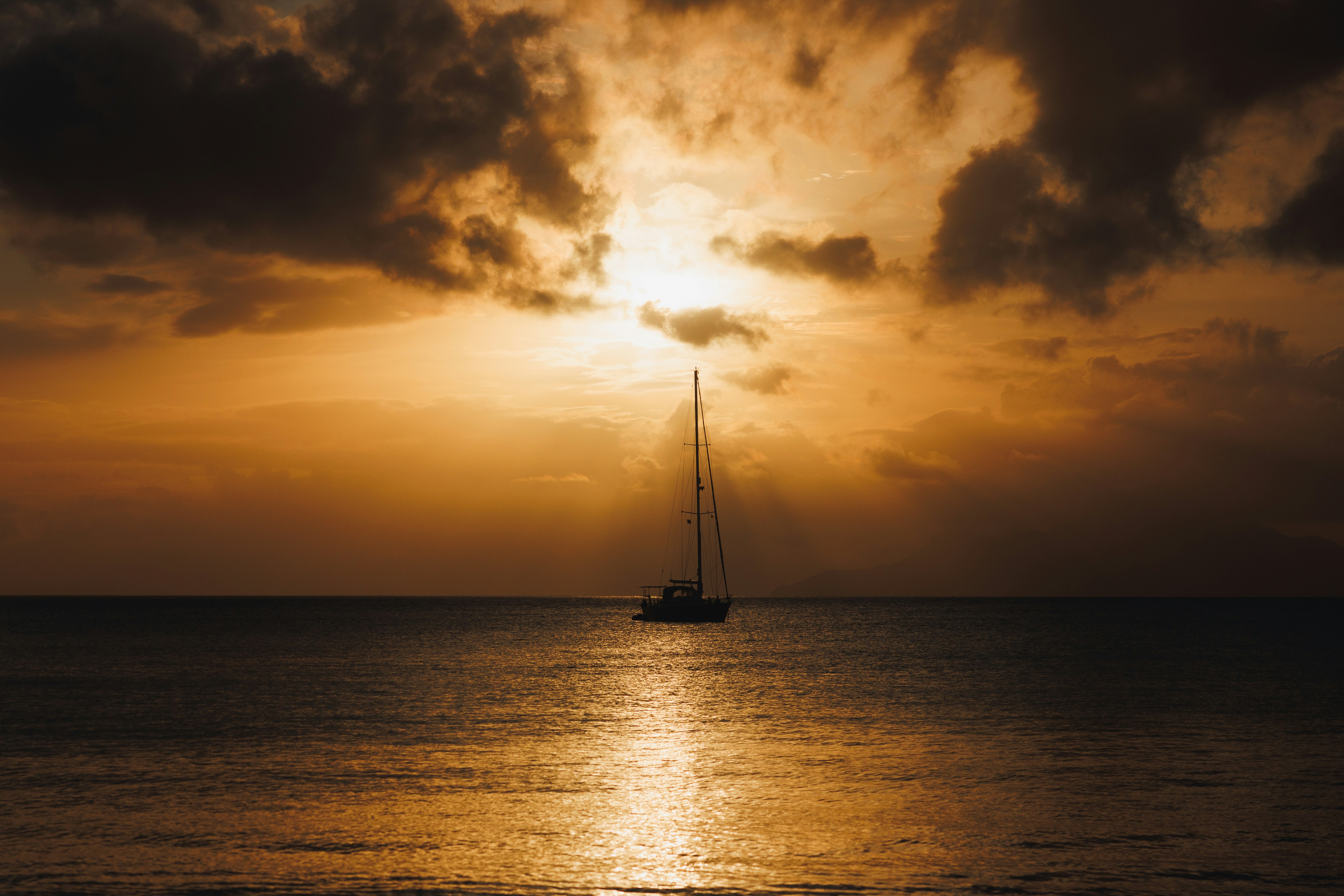 a sailboat in the ocean at sunset