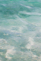 Turquoise mineral bath water swirling gently as magnesium crystals dissolve, creating a soothing ripple effect.