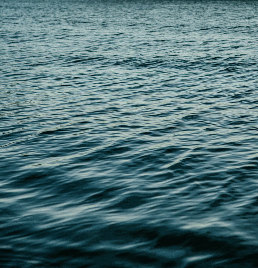 a large body of water with a boat in the distance