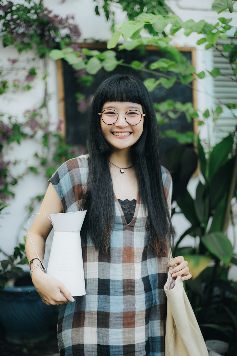 a woman wearing glasses and holding a paper bag