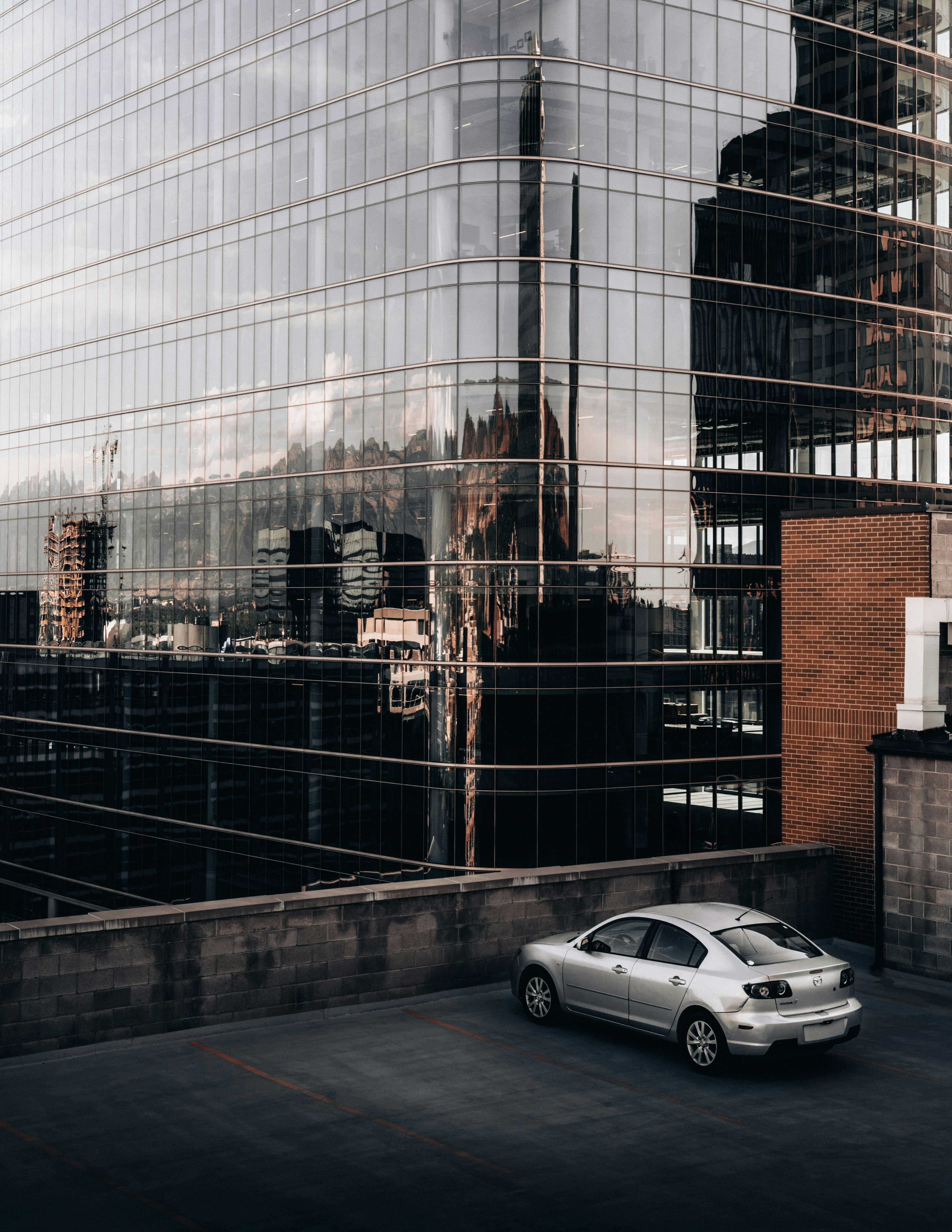 The modernity of the glass building and moody atmosphere creates a sense of wonder and intrigue.