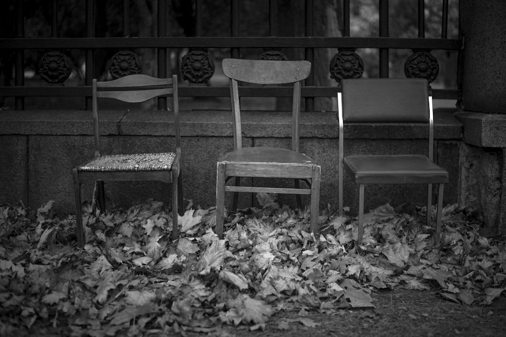 a couple of chairs sitting on top of a pile of leaves