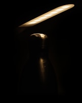 Product photography of a handcrafted bottle with subtle reflections on a dark surface.