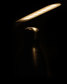Close-up of Flash Bar Pro’s integrated lighting illuminating a bottle cap in a dim bar.