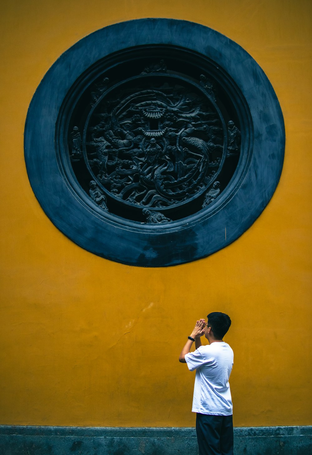 a man standing in front of a yellow wall