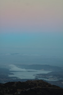 A serene landscape painting capturing a misty morning by a lake with soft pastel tones.