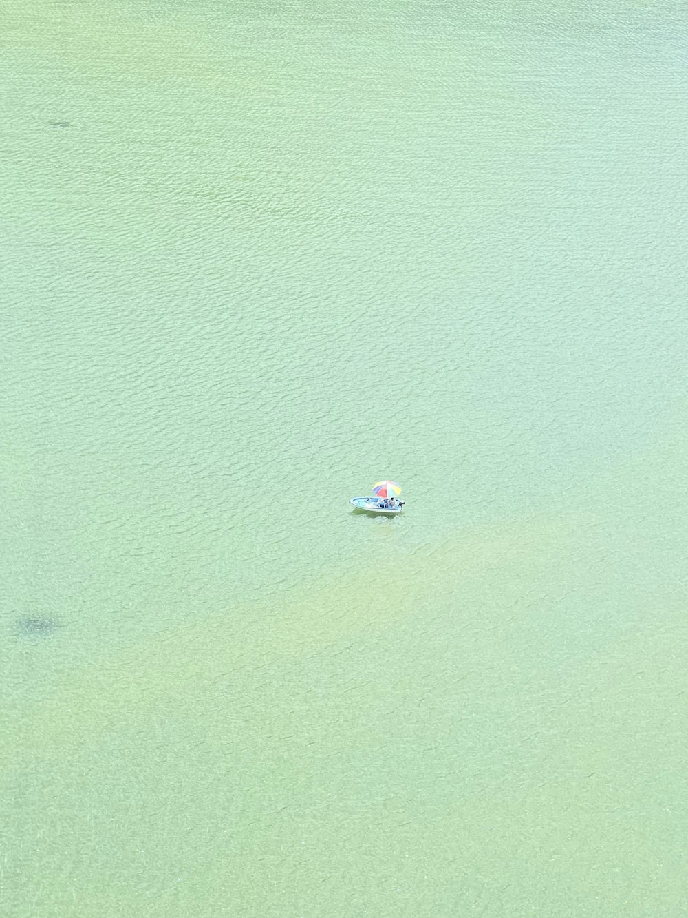 a small boat floating on top of a lake