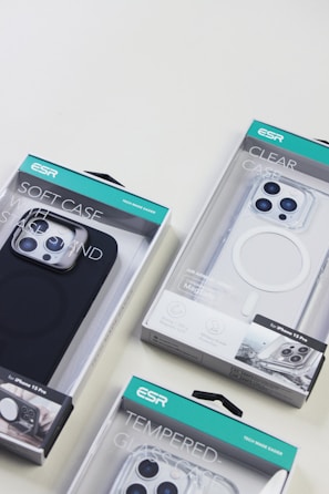 Several ESR brand phone cases in various packaging designs, including a soft case, a clear case, and a tempered glass case, displayed on a light surface.