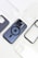 Multiple phone cases are arranged around a smartphone with a distinctive camera setup. The phone is in the center, featuring a dark case with a visible Apple logo and a circular MagSafe design. The surrounding cases are varied, including a carbon fiber pattern and several clear cases.
