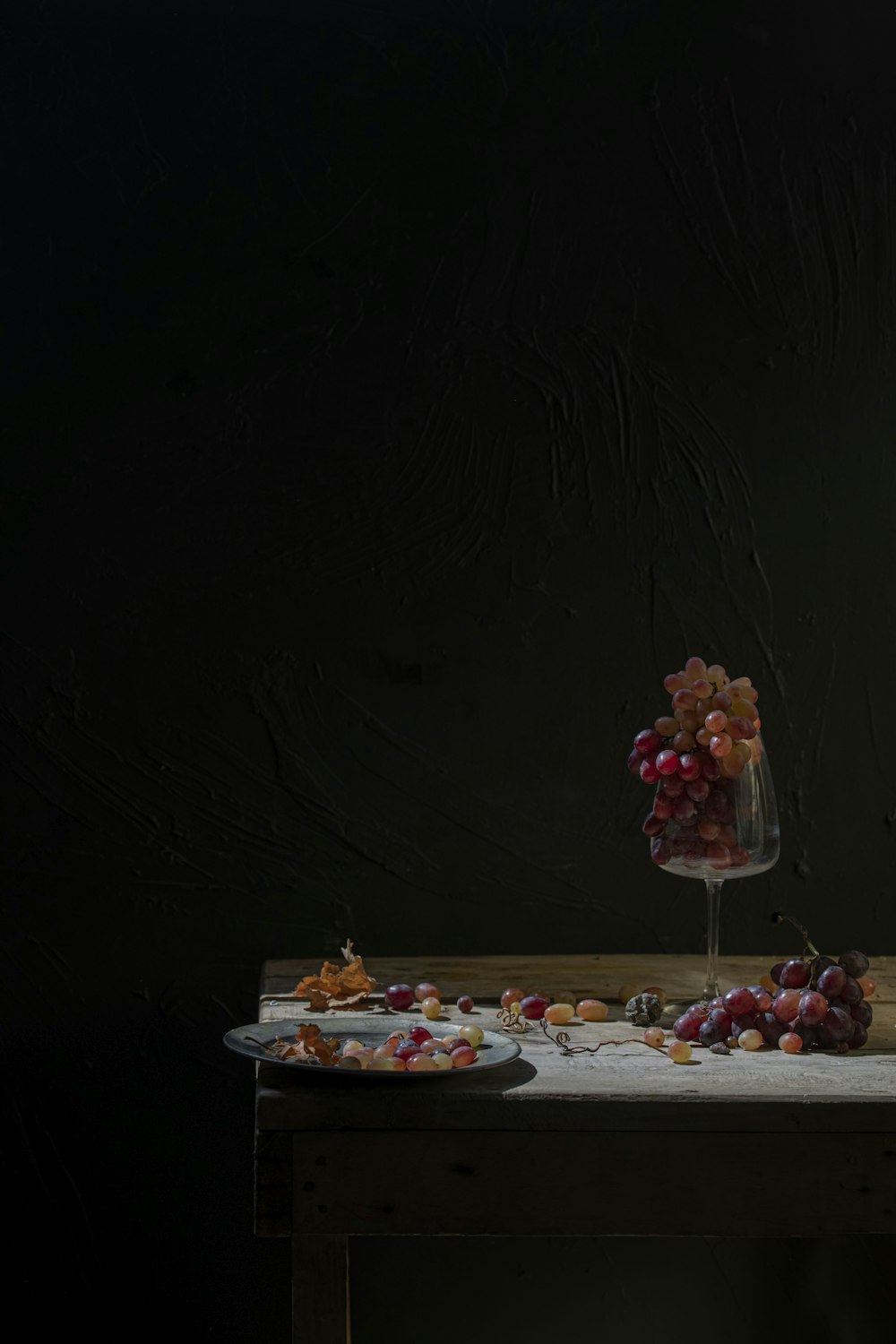 a table topped with a bowl of grapes next to a plate of food