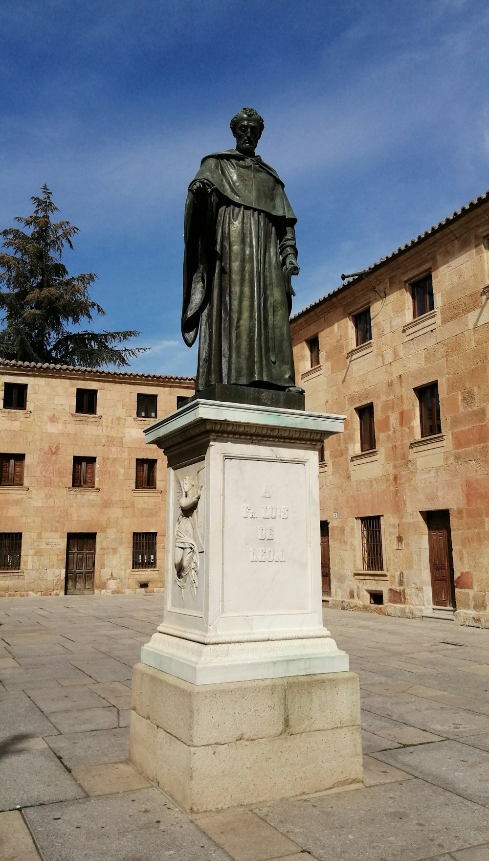 une statue d’un homme debout dans une cour