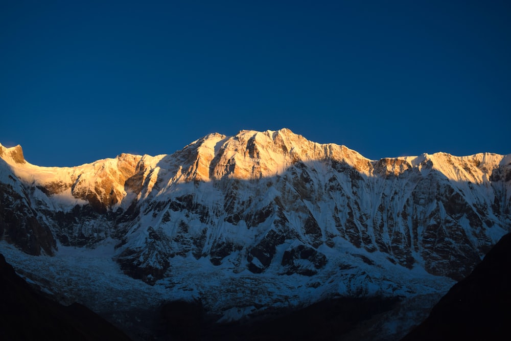 a snow covered mountain with a blue sky in the background