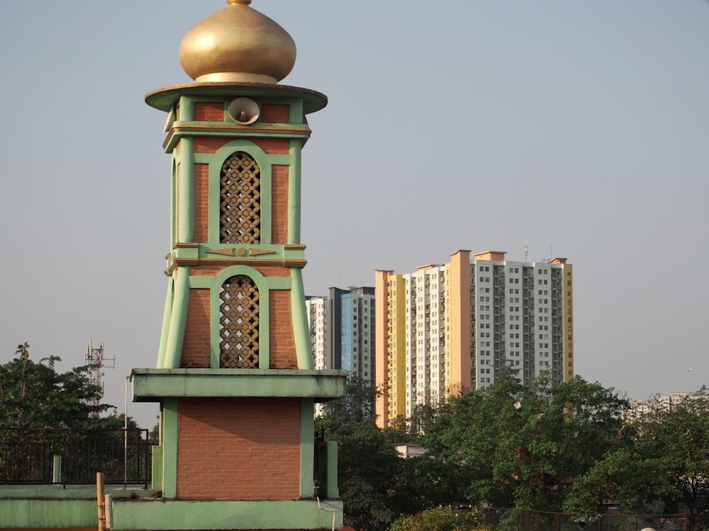 a tall clock tower with a gold dome on top