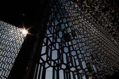 Architectural metal facade with intricate geometric patterns catching sunlight.
