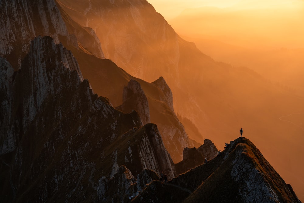 a person standing on top of a mountain at sunset