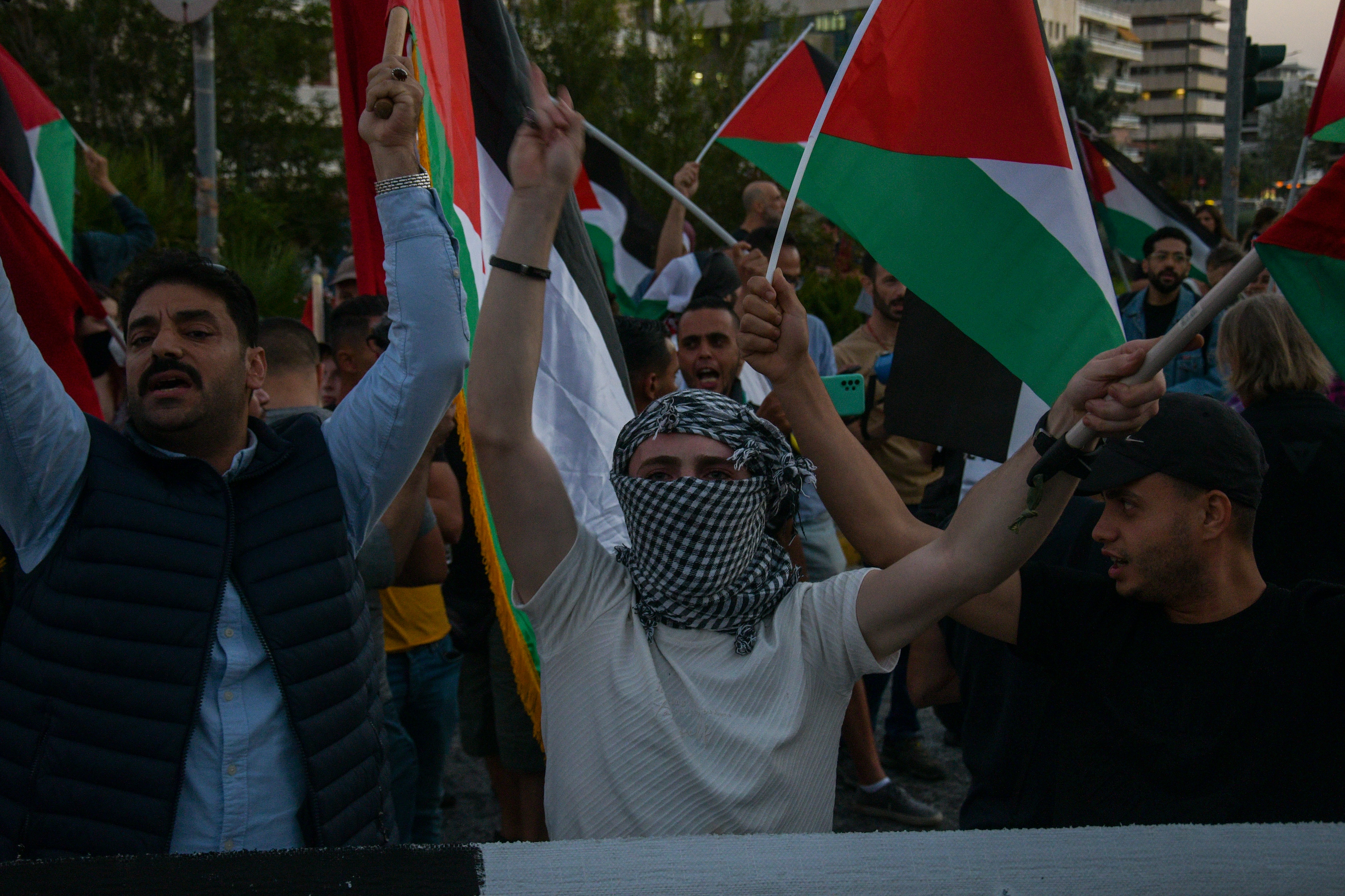 a group of people holding flags in the air