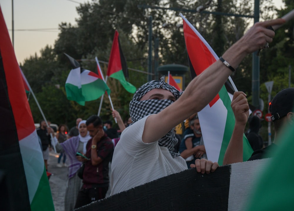 a group of people holding flags and wearing masks