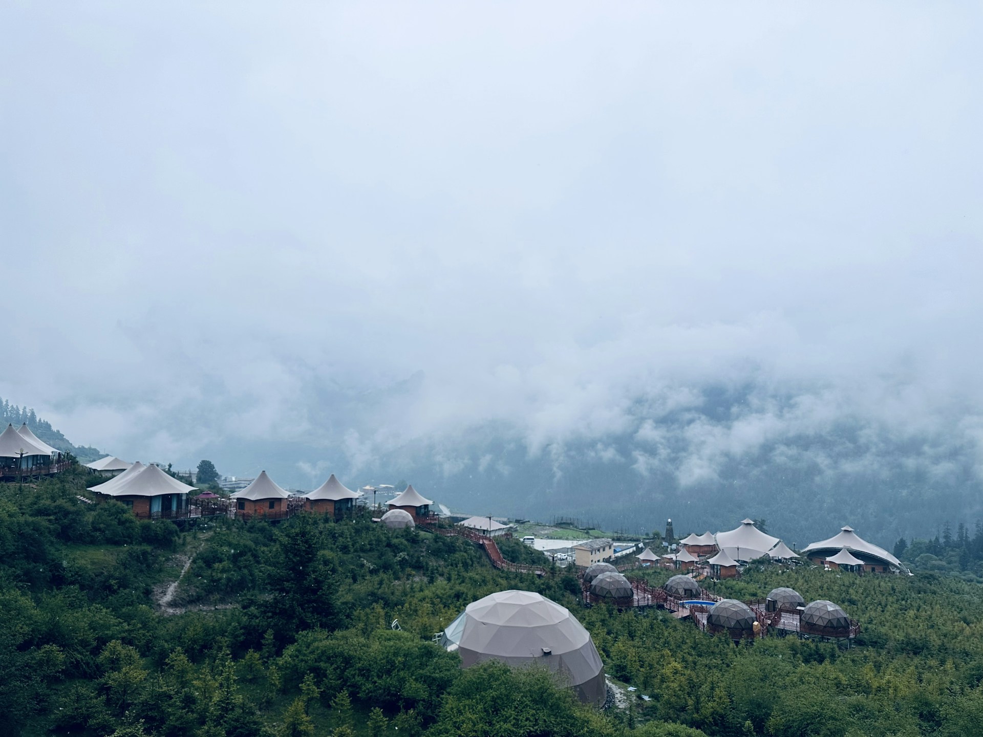 Trekking group resting beside the serene Segara Anak lake, surrounded by lush greenery and misty mountain air.