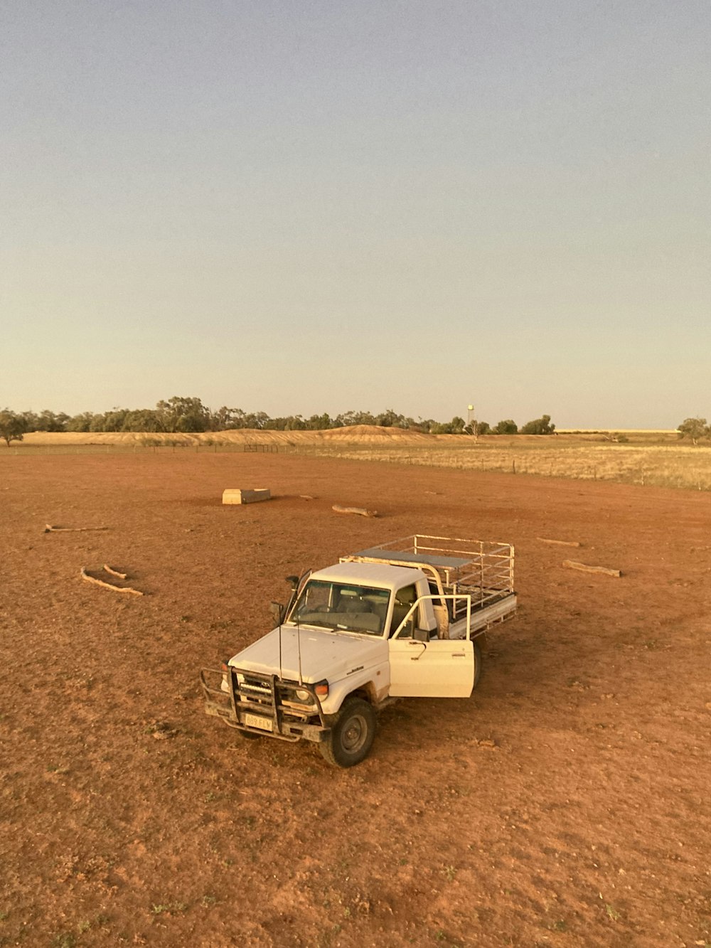 a truck parked in the middle of a dirt field