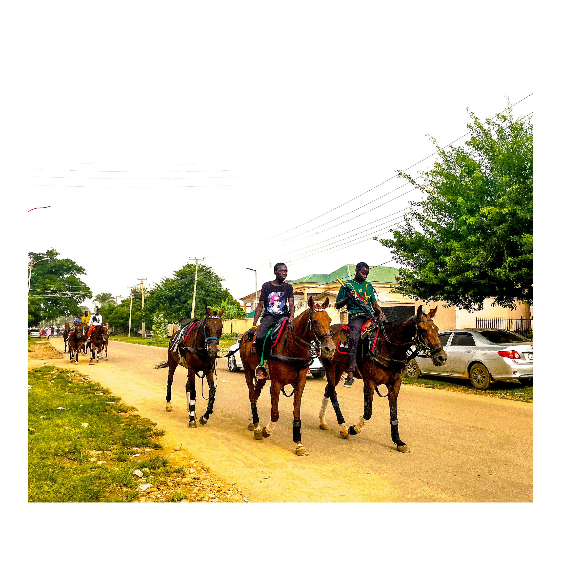 um grupo de pessoas andando a cavalo por uma estrada de terra