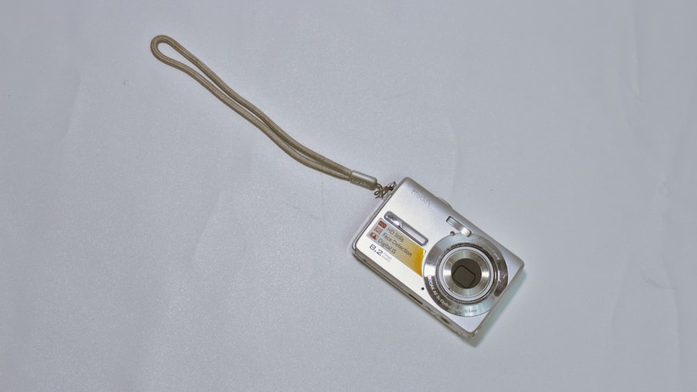 Eine silberne Kamera sitzt auf einem weißen Tisch