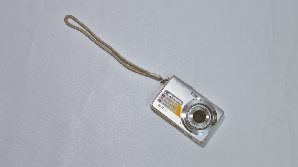 a silver camera sitting on top of a white table