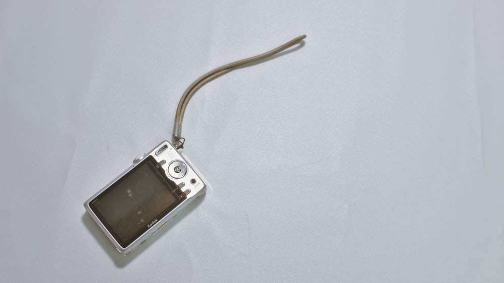 a small silver camera on a white surface